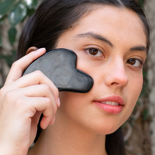 Guasha de obsidiana para masaje facial aplicada en modelo